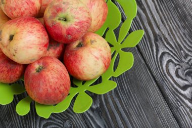 Elmalar vazoda. Fırçalanmış tahtalarda, siyah beyaz boyanmış..