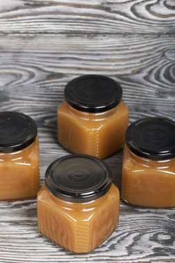 Kavanozda elma reçeli. Fırçalanmış tahtalarda, siyah beyaz boyanmış..