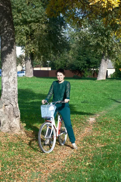Дівчина Зеленому Костюмі Стоячи Тримаючи Кермо Велосипеда Шляху Опалим Жовтим — стокове фото