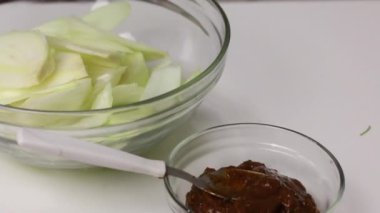 Bir parça pastırma, akordeon şeklinde kesilmiş. Maydanozla dolu. Konteynırda Adjika ve soğan. Bitki ve baharatlı tuzlanmış domuz yağı..