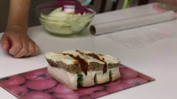 A piece of bacon, cut into an accordion. Filled with parsley and adjika. The woman sprinkles it with salt and pepper. Salted lard with herbs and spices. — Stock Footage A piece of bacon, cut into an accordion. Filled with parsley and adjika. The woman sprinkles it with salt and pepper. Salted lard with herbs and spices. Video Clip