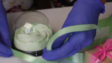 Plastik bir kapta Zephyr. Kadın onu bir kurdeleyle bağlıyor. Yakın çekim..