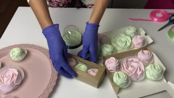 Una mujer presenta zephyr rosa y verde claro en cajas de cartón de regalo — Vídeo de stock