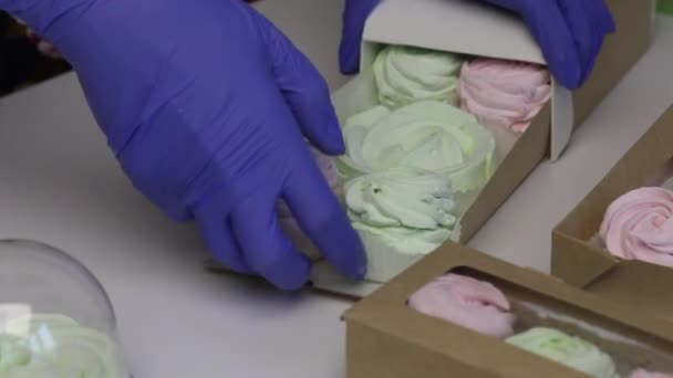 Vrouw verpakt marshmallows in kartonnen dozen. Nabijgelegen accessoires voor verpakking. Close-up opname — Stockvideo