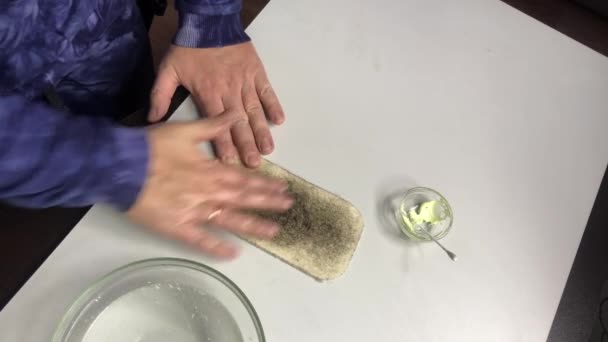 Patination des pièces de cuivre avec onguent sulfurique. Un homme frotte une pièce sur un feutre. Montre le relief de la pièce. — Video