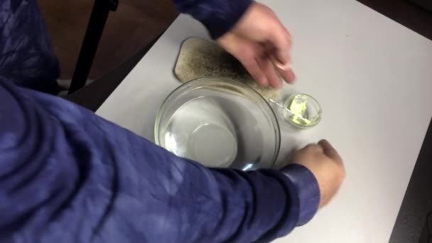Patineren van koperen munten met zwavelzalf. Een man wrijft een munt met zwavelzalf in heet water.. — Stockvideo