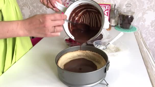 Μια γυναίκα χύνει σοκολατένια γκανάς πάνω από ένα κέικ σφουγγαριού. Μαγειρική Levington Pie. — Αρχείο Βίντεο