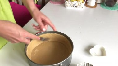 Bir kadın hamuru katlanabilir bir turta tavasına çatalla deliyor. Levington Turtası Pişirme.