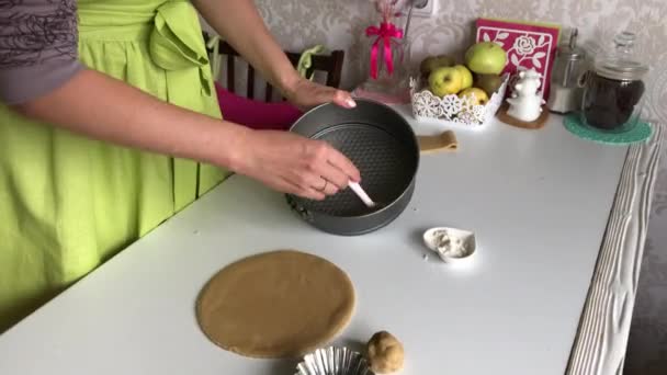 Egy nő napraforgóolajjal zsírozza össze az összecsukható tortát. Levington pite főzés. — Stock videók