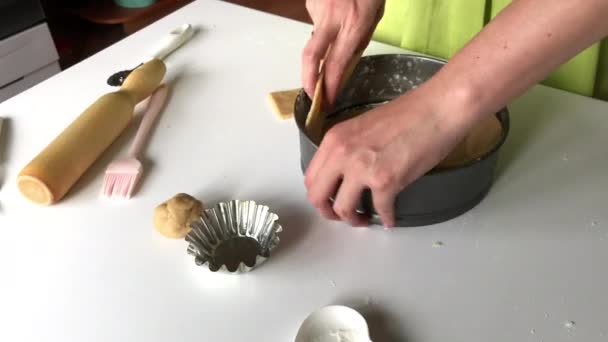 一个女人把面团放进一个可折叠的蛋糕锅里.煮李文顿派. — 图库视频影像