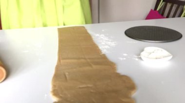 Kadın hamuru kesiyor. Yemek aletleri yakınlarda. Levington keki, hazırlık aşamaları..