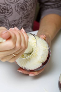 Bir kadın ahududulu reçelli krem peynirden tatlı yapar. Malzemeler masa yüzeyine serildi. Kurabiye, ahududu ve nane ile süslenmiş..