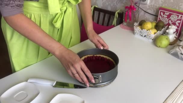 La femme sort le gâteau de Levington du moule. Un gâteau décoré de framboises. — Video