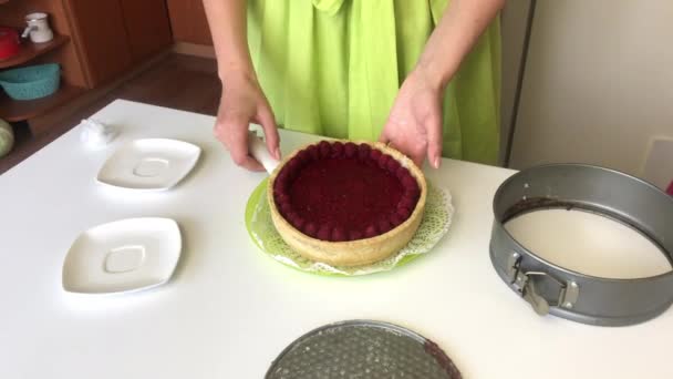 Kvinnan tar ut Levingtons tårta ur formen. En tårta dekorerad med hallon — Stockvideo