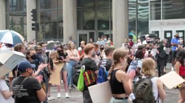 St. Paul, Minnesota 'da. 8 Ağustos 2020. Okullarımızda protesto eden polis yok. Protestocular şiddetli yağmurdan sırılsıklam olurken hoparlörün konuşmasını ve maske takmasını dinliyorlar..