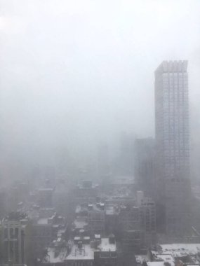 Sisli New York 'ta ofis penceresinden dışarı bakıyorum. Görüş mesafesi düşük, New York gökyüzü sisle kaplı ve fırtına sırasında yağmur yağıyor. Sisteki ofis penceresinden Manhattan manzarası.