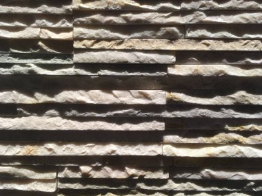 İnce kayalık katmanlar, pürüzlü ve pürüzlü. Farklı kalınlıkta granitin iç duvarı yatay olarak yerleştirilmiş. Kayalık arkaplan.