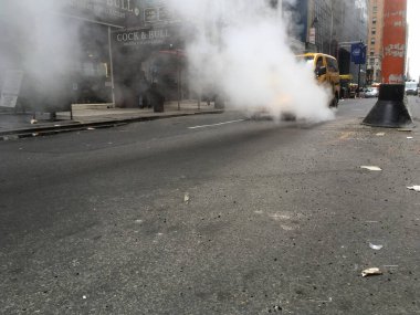 19 Şubat 2018 - New York Şehri: Manhattan şehir merkezindeki bir kanalizasyon kapağından sıcak buhar çıkıyor. Yeraltı ısıtma sisteminden çıkan sıcak buhar, caddedeki sarı taksi....