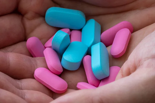 Comprimidos Ovais Rosa Azul Nas Palmas Das Mãos — Fotografia de Stock