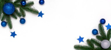 Köknar dalları, beyaz arka planda mavi ve gümüş süslemeleri olan bir Noel tablosu. Noel kompozisyonu, üst görünüm, kopyalama alanı. Yeni yıl arkaplanı.