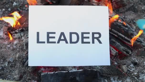Líder de palavra em uma folha de papel branco queima em um fogo contra. Movimento lento — Vídeo de Stock
