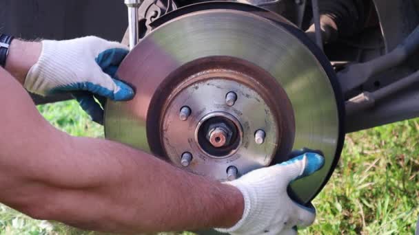 A gloved mechanic carefully removes the brake Rotor from the hub. FullHD — Stock Video