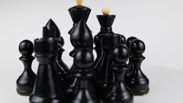 Piezas de ajedrez negro giran sobre un fondo blanco 360 grados. Movimiento lento — Vídeo de stock