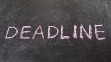 Deadline kelimesi siyah tahtaya pembe tebeşirle işaretlenmiş. Tam HD