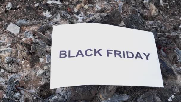 Woord Zwarte vrijdag op een wit vel papier brandt in een vuur tegen. — Stockvideo