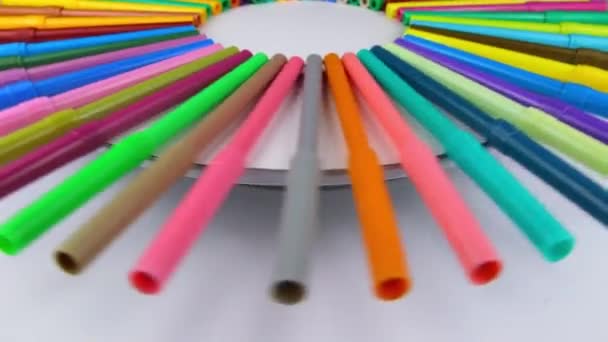 Multi-colored markers rotate 360 degrees on a round white table. Slow motion — Stock Video