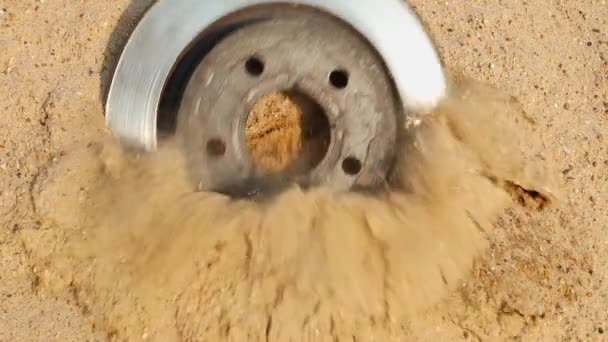 Disco de freno de coche cae desde arriba en una pila de arena. Cámara lenta, imágenes FullHD — Vídeos de Stock