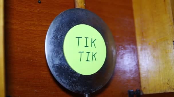 Una pegatina con la inscripción Tick Tick se pega en el péndulo del reloj — Vídeos de Stock