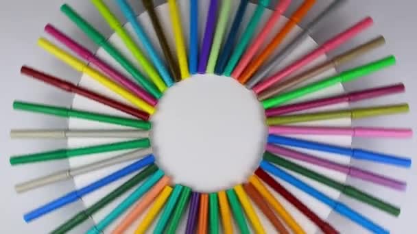 Les marqueurs multicolores tournent à 360 degrés sur une table ronde blanche. Vue du dessus — Video