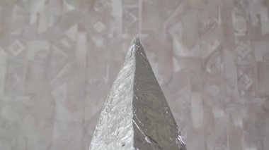 Folyodan yapılmış bir piramit insan kafasına takılır.