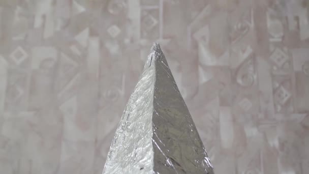 Una pirámide hecha de papel de aluminio se viste en una cabeza humana, vista trasera — Vídeo de stock