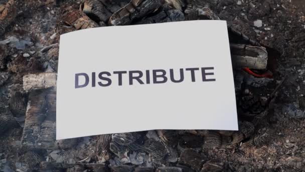 Mot Distribuer sur une feuille blanche de papier brûle dans un feu contre. Mouvement lent — Video