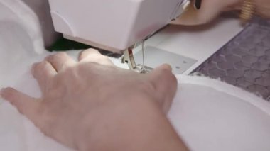 Bir terzinin elleri dikiş makinesine kumaş parçaları diker. Tam HD
