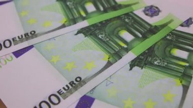 100 Euro 'luk banknotlar masada dönüyor. Kağıt paranın dönüşü, yakın plan, FullHD