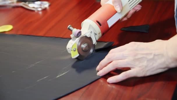 工人们在一张褐色的桌子上用电刀割破了几层深色的组织.FullHD — 图库视频影像