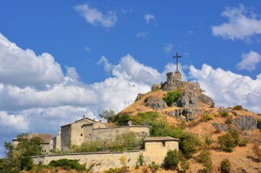 Pennabilli, Rimini, Emilia-Romagna. Eski Billi kalesinin kalıntıları ve İtalya 'nın en güzel köylerinden biri olan Pennabilli uçurumunun tepesindeki büyük metal haç..