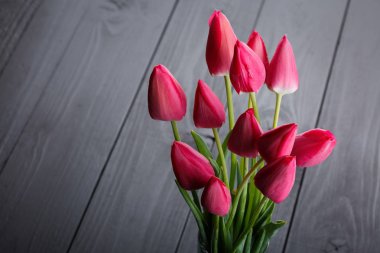 siyah ahşap masa üzerinde pembe laleler