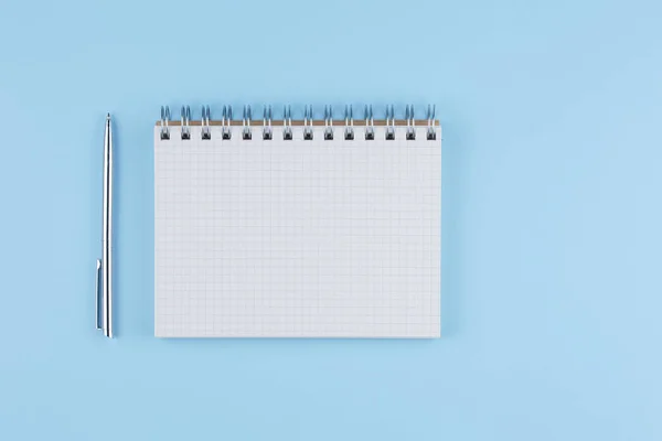 Cuaderno de la escuela con pluma en una vista superior mesa azul — Foto de Stock