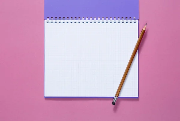 Top view of a open notebook with pencil on a purple background — Stock Photo, Image