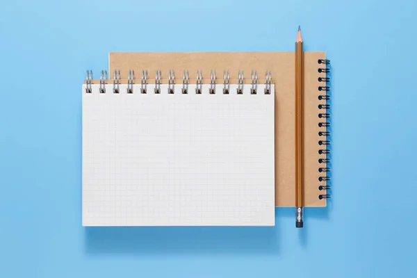 Övre vy av öppen anteckningsbok med blyertspenna på blå bakgrund — Stockfoto