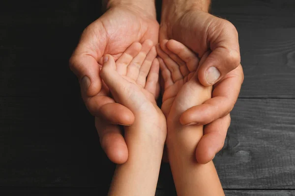 Mani adulte che tengono per mano il bambino, concetto di assistenza alla famiglia — Foto Stock