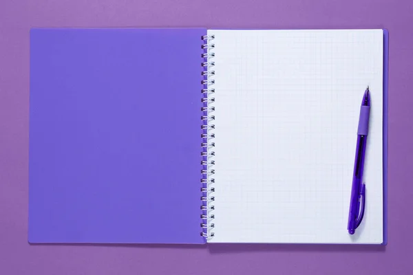 Top view of a open notebook with pen on a purple background — Stock Photo, Image