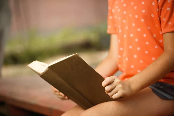 Menina bonito está lendo ao ar livre em um dia ensolarado, dia internacional de alfabetização . — Fotografia de Stock