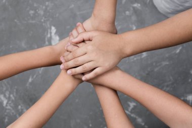 çocuklar gri arka plan üzerinde avuç içi aşağı bir daire içinde el