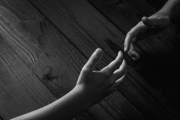 Les bras s'étirent et se tiennent l'un l'autre sur un fond en bois noir.noir et blanc . — Photo