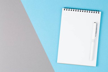 boş sayfa ile mavi ve gri masa üst görünümünde kalemile açık not defteri
